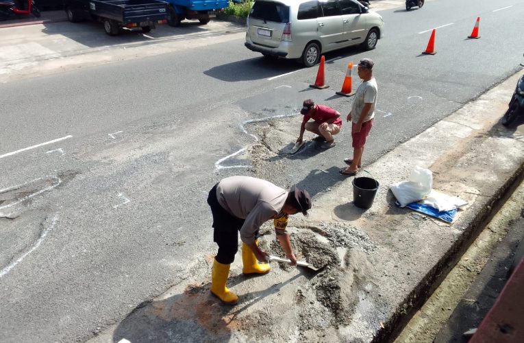 Bhabinkamtibmas Tanjung Unggat Bersama Warga Gotong Royong Semenisasi Jalan Rusak